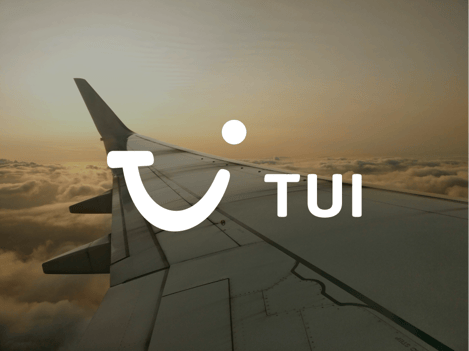 The image shows an airplane wing above the clouds, with a sunset or sunrise in the background. The TUI logo is prominently displayed in the center of the image. The logo features a smiley face created by the letter