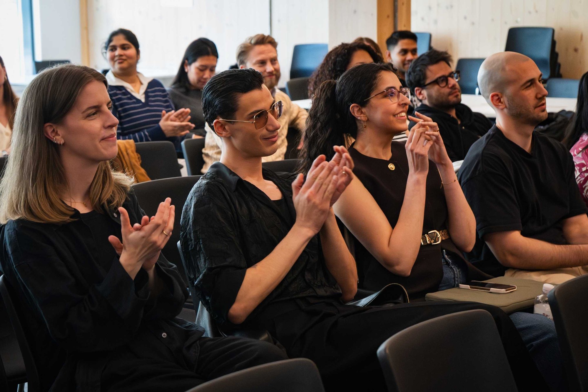 Students watching the presentations and applauding