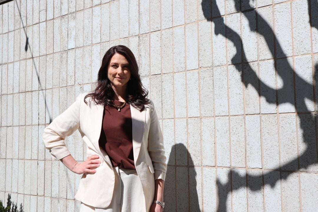 Heidi Rundt, CEO of Hyper Island, standing outdoors against a tiled wall in sunlight.