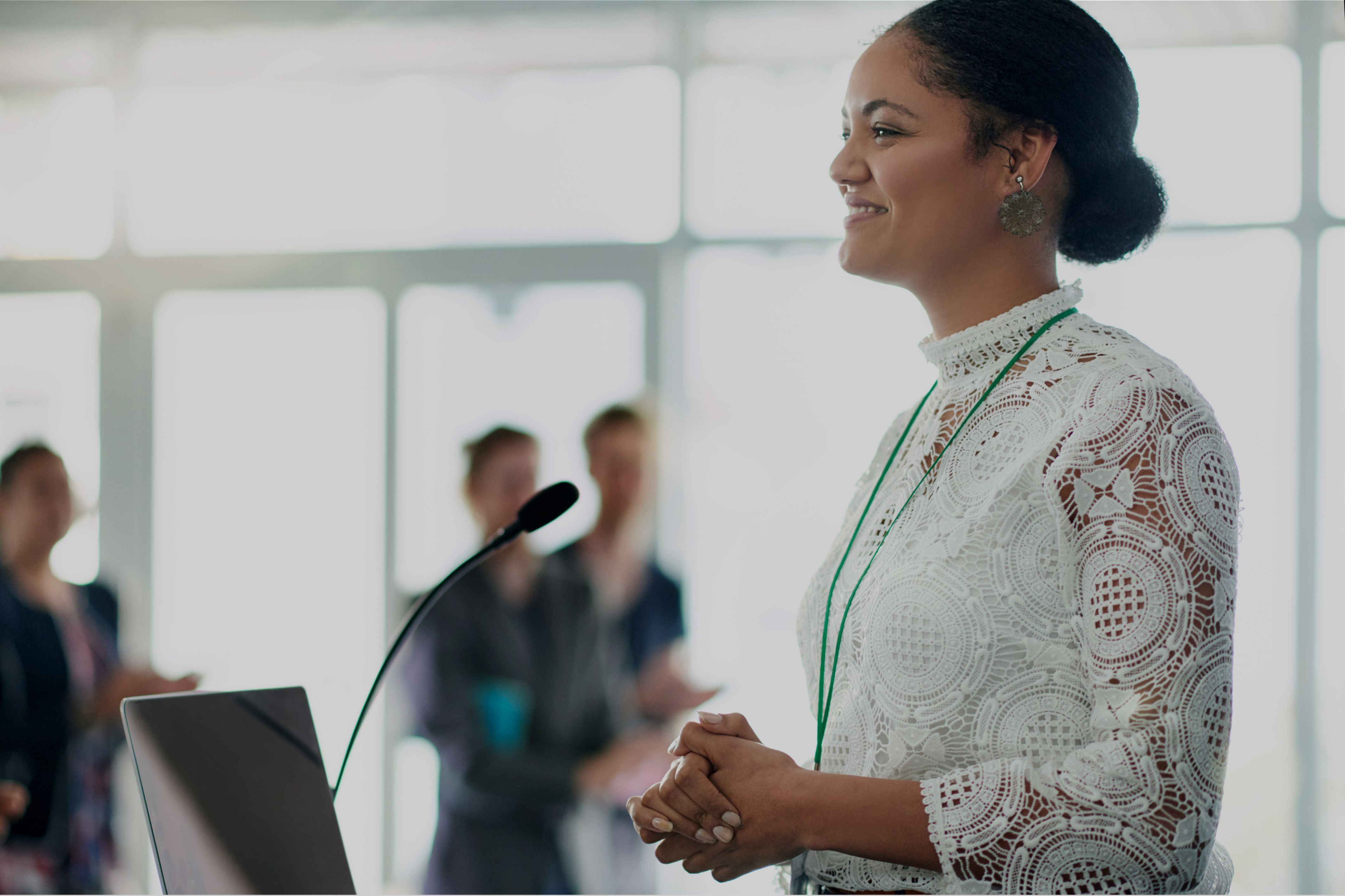 A confident speaker at a podium, representing how expert facilitation is transforming industries by effectively sharing knowledge at conferences and events.
