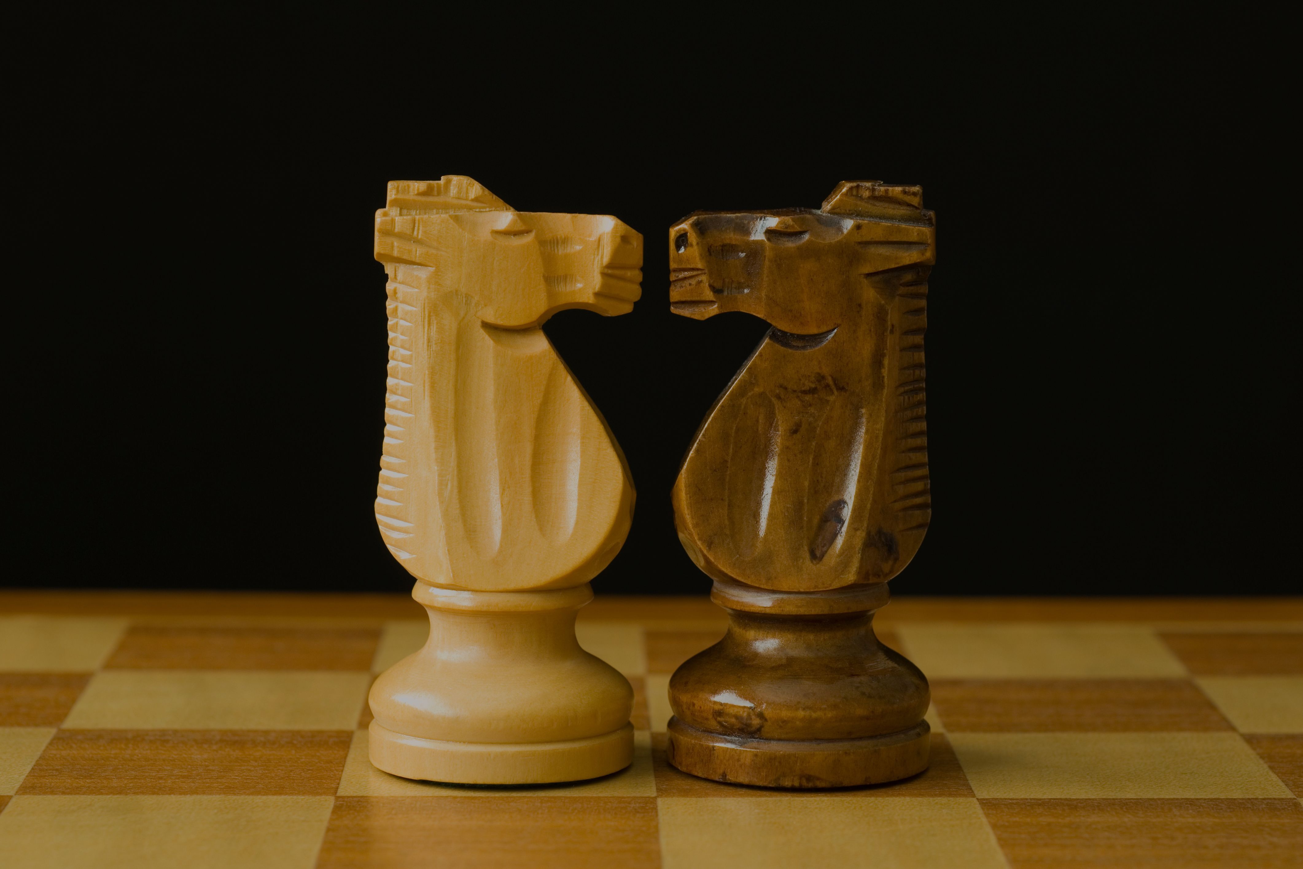 Two chess knights face to face on a chessboard, representing the strategic contrast between growth and traditional marketing.
